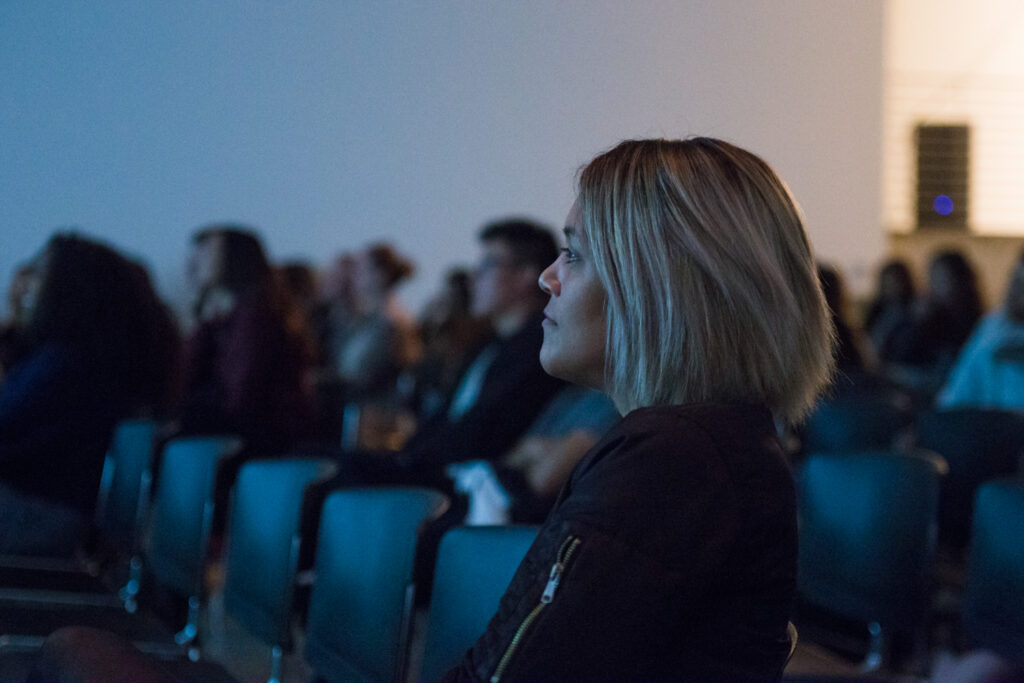 Audience member looking at the work of Angela Washko.