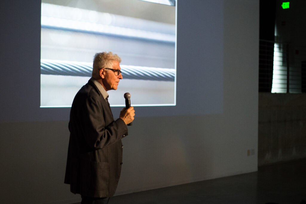 Bill Fontana standing up, talking into a microphone.