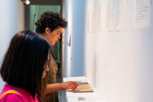 Person flipping through a book at the DMA senior show.