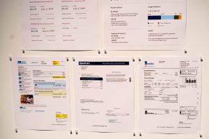 Printout of internet bill, water bill, and gas bill on paper.