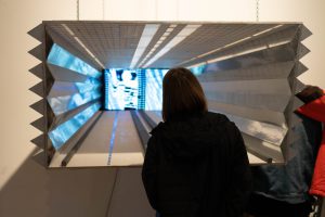 Sculpture of a highway leading into the view of a television monitor.