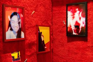 Red carpet wall with mounted photographs of a woman dancing.