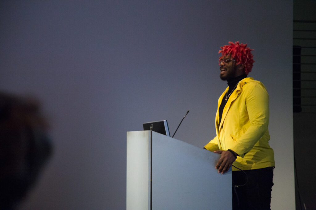 Ka5sh at the EDA pit podium wearing a yellow jacket.