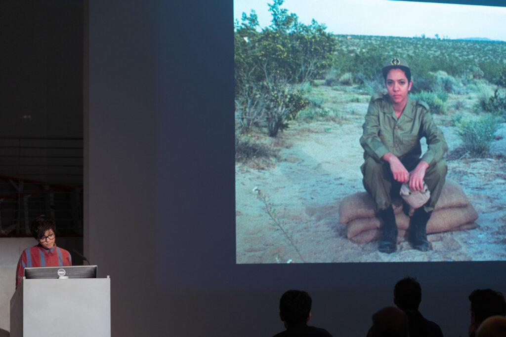 Person dressed in military wear is projected onto the EDA pit wall.