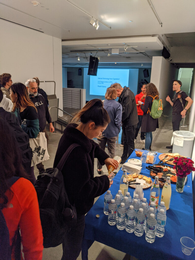 People eating food and socializing at MASAKI FUJIHATA's presentation.