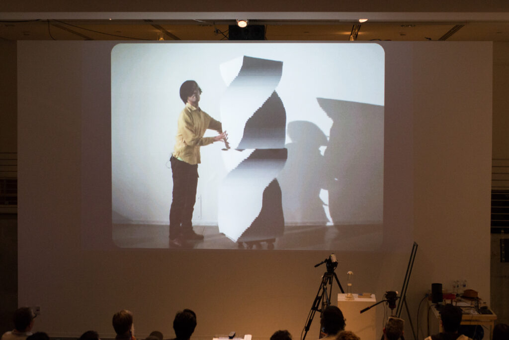 Live slit screening video manipulation of Toshio Iwai in front of a wall.