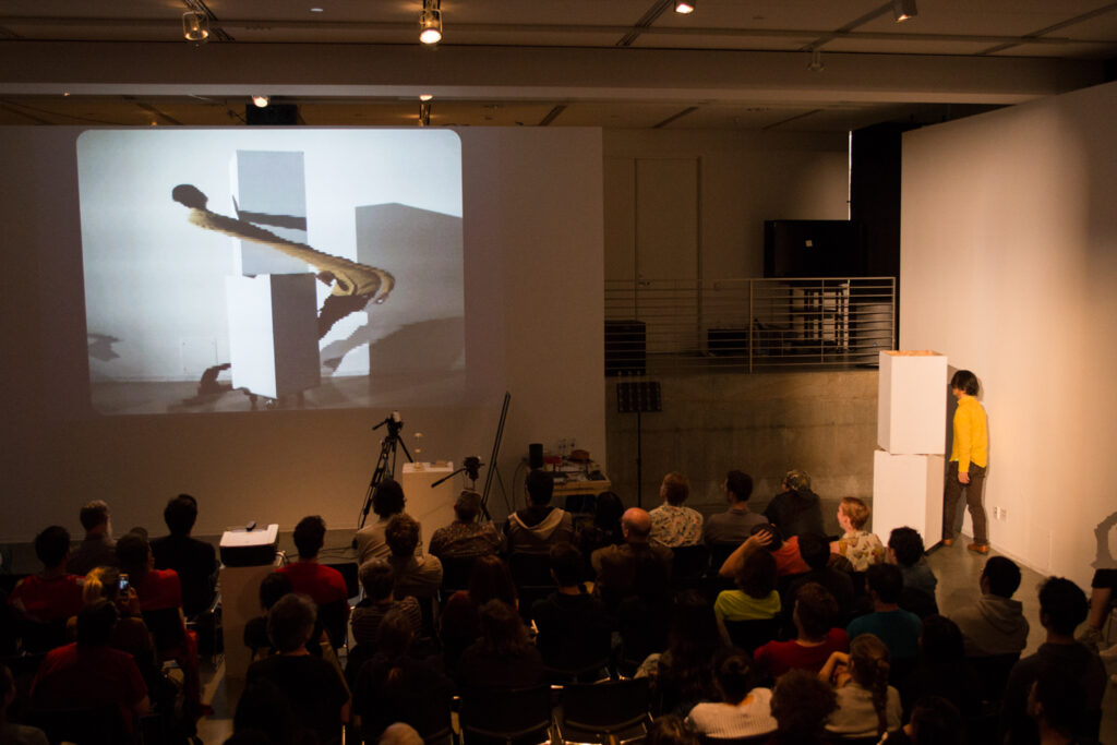 Live slit screening video manipulation of Toshio Iwai in front of a wall.