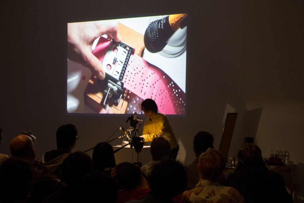 Toshio Iwai is micing up an instrument in the EDA pit.