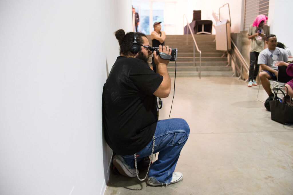 Person holding a camera to their face filming Yung Jake's lecture.