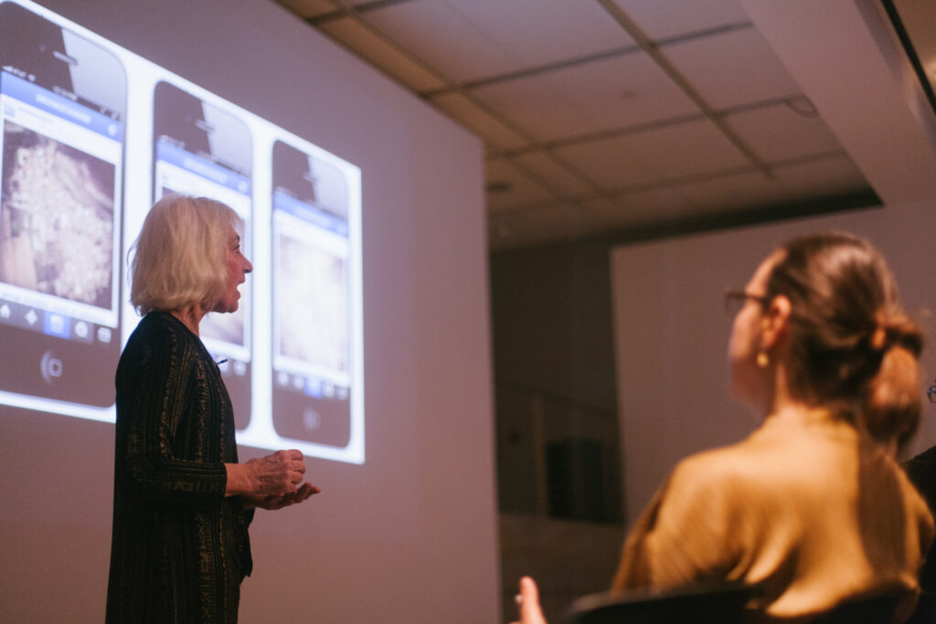 Linda Weintraub is standing in front of her power point slide displaying phones.