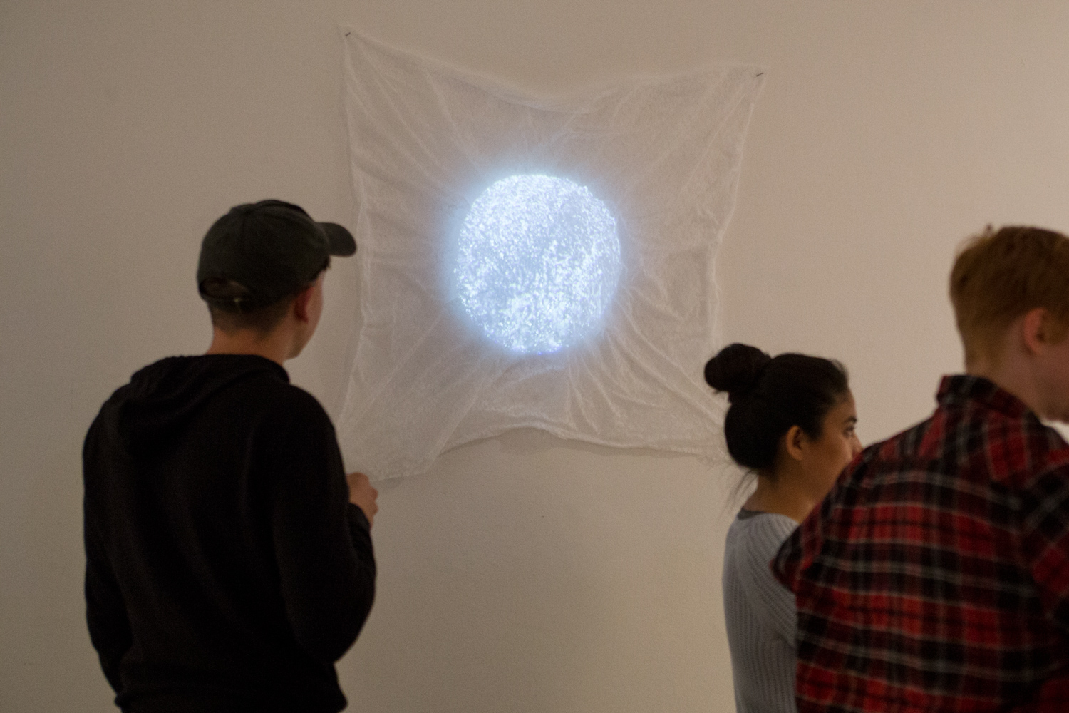Circular projection on top of white fabric at Sam Congdon's solo show.