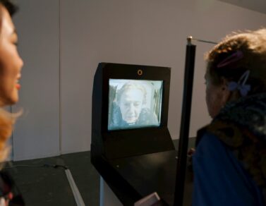 Person standing in front of of a camera and display which displays the person as older than they really are.