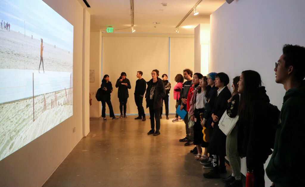 People look at Harvey Moon's projection work during Harvey Moon's exhibition opening.