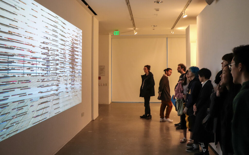 People look at Harvey Moon's projection work during Harvey Moon's exhibition opening.