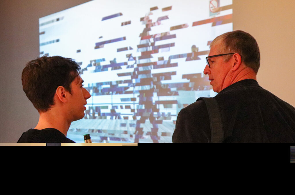 Harvey Moon talks to Peter Lunenfeld in front of Harvey's projection work.