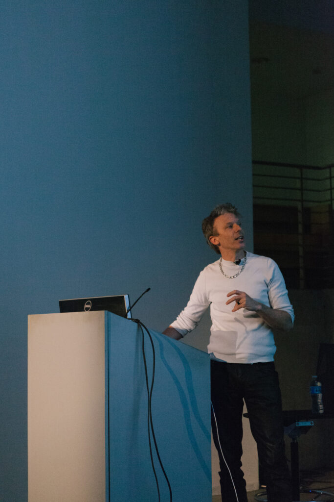 Person speaking at a pedestal during Daniel Landau's lecture.