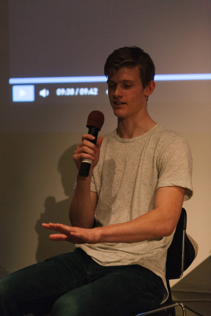 Person is holding a microphone with a purple pop cover over the microphone.