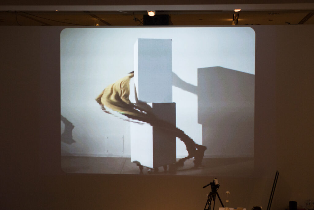 Live slit screening video manipulation of Toshio Iwai in front of a wall.
