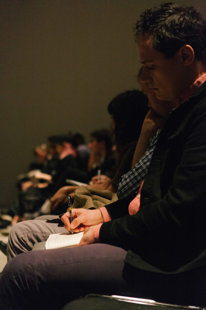 Person taking notes at Zizek's lecture.