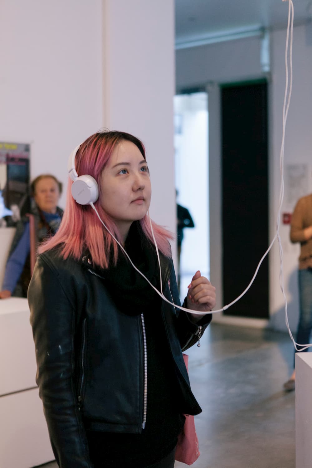 Person wearing headphones looking up at a monitor pictured out of frame.