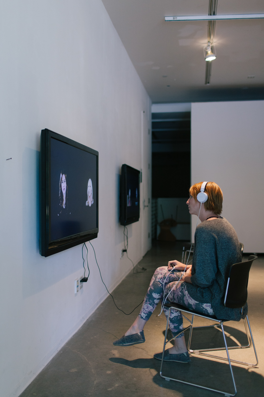 Person with headphones sitting in front of Iglesias' solo show work.