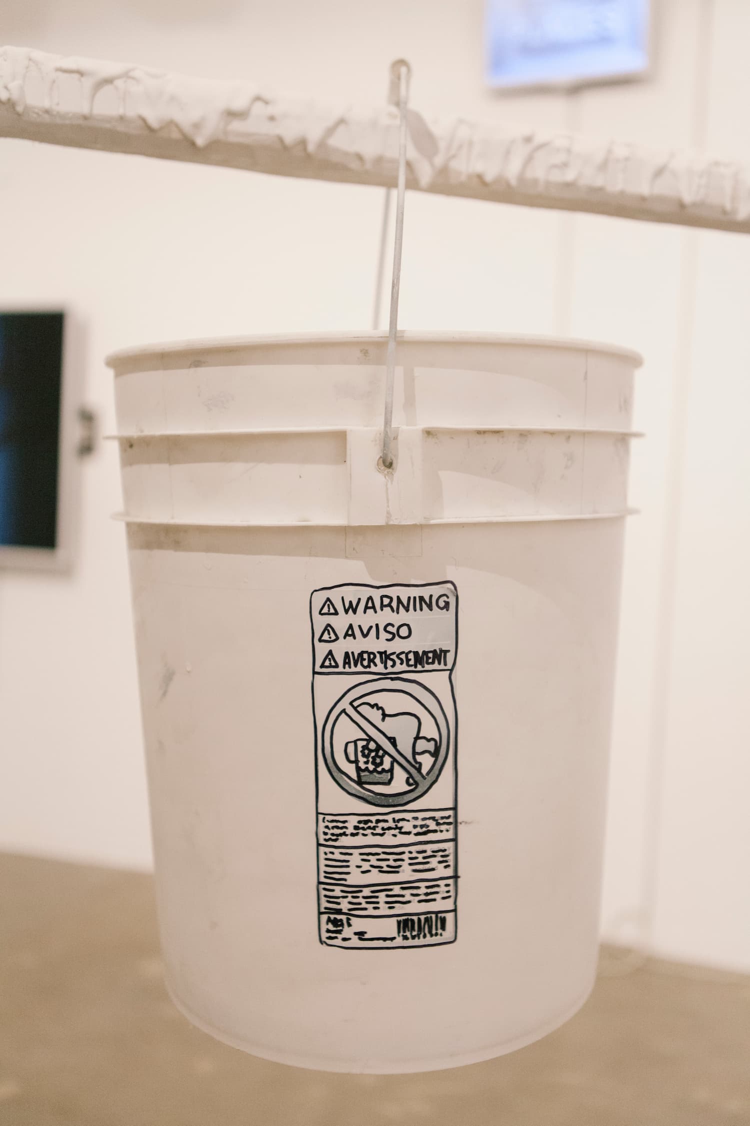 A white painter bucket hung on a frame during Stalgia Grigg's solo show.