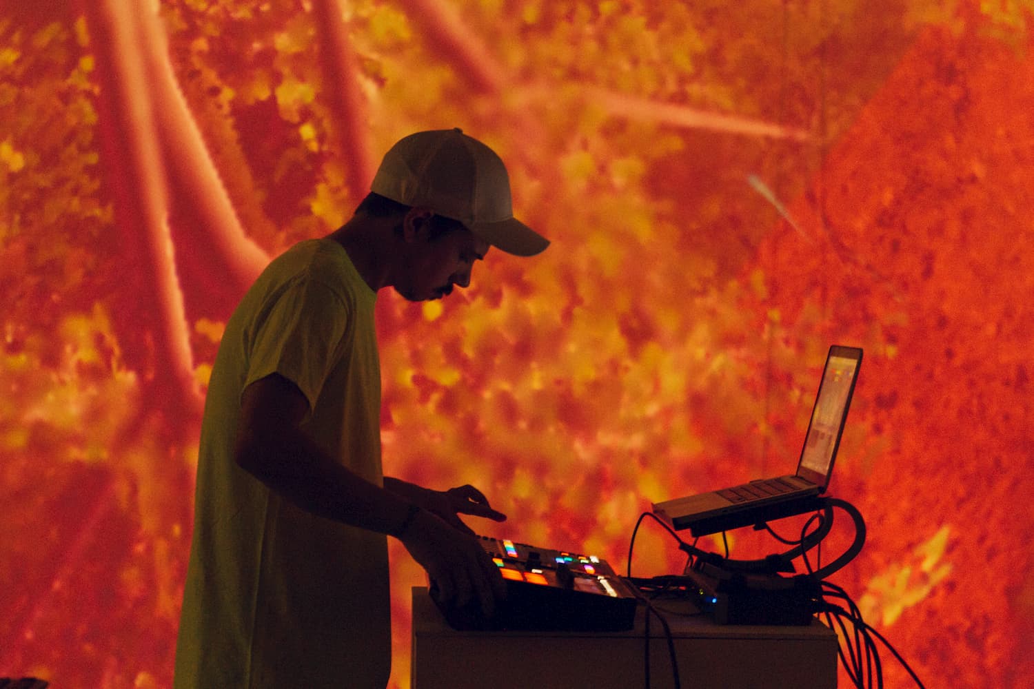 Person mixing audio in front of red hue projection visual.