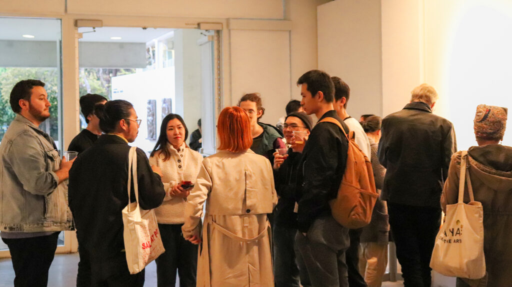 People socializing at the opening of Zheng Fang's exhibition.